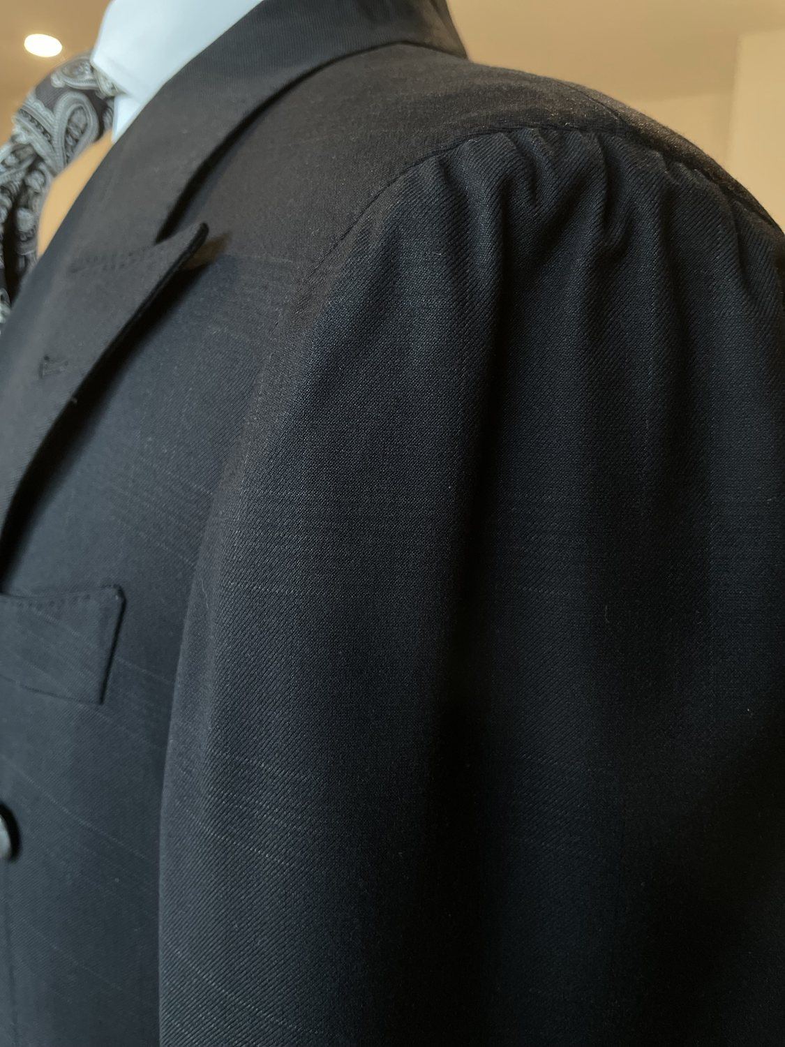 Black custom suit shoulder and lapel detail