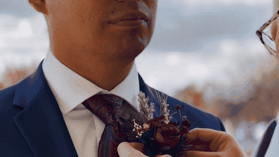 Boutonniere being pinned for a wedding suit